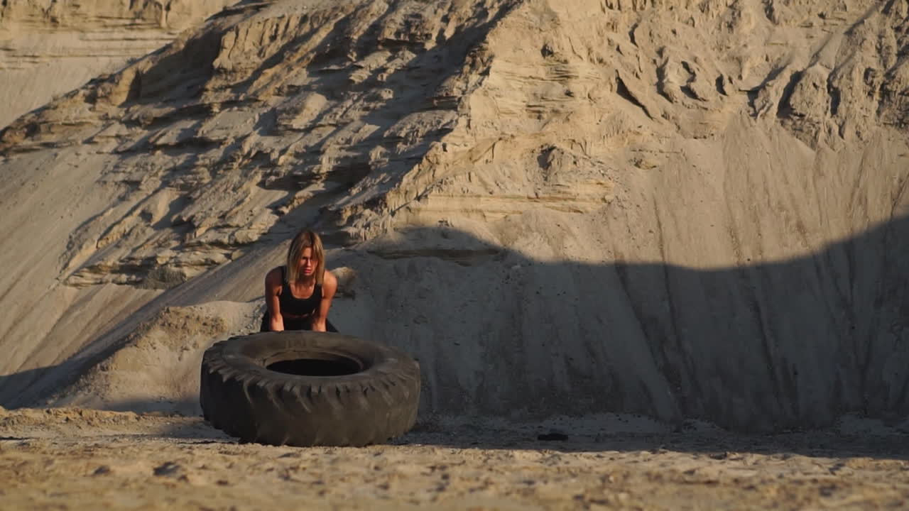 chica en una cantera empujando la rueda en el entrenamiento de crossfit