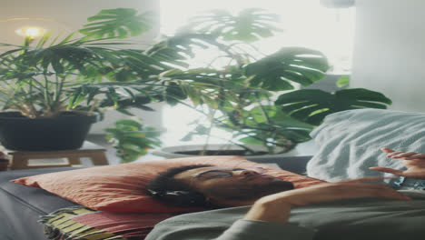 man lying on sofa and enjoying music