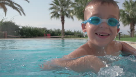 un movimiento lento de un niño feliz salpicando en una piscina abierta