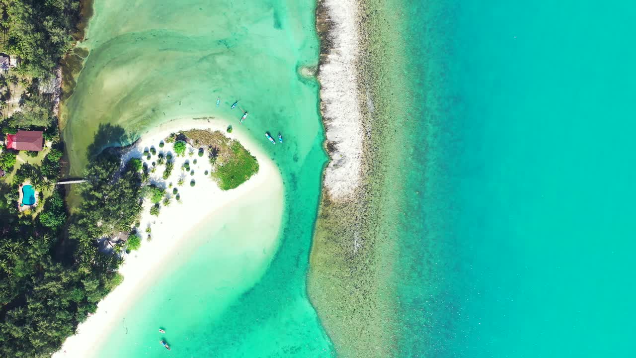 Beautiful shore of tropical island with white sandy beach and coral reef barrier washed by turquoise lagoon near holiday resort in Thailand