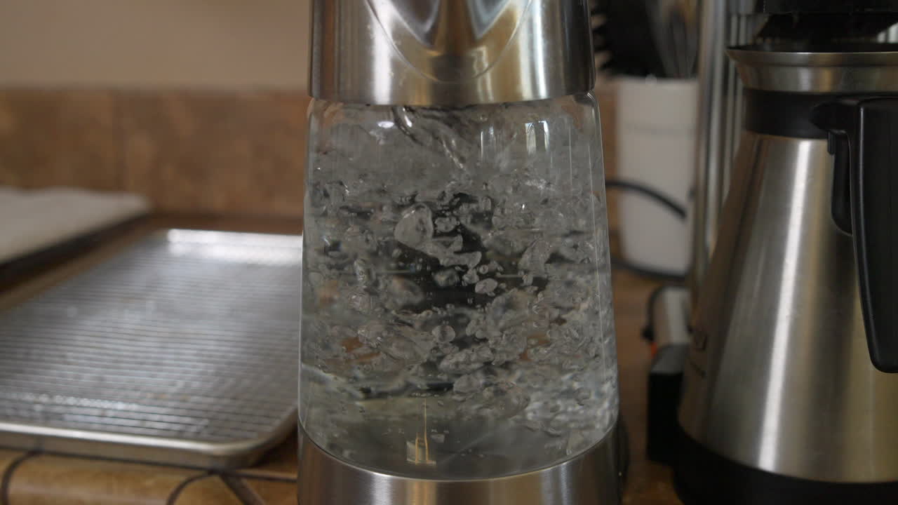 커피메이커에 의해 투명한 유리 주전자에 물이 끓고 거품이 일다