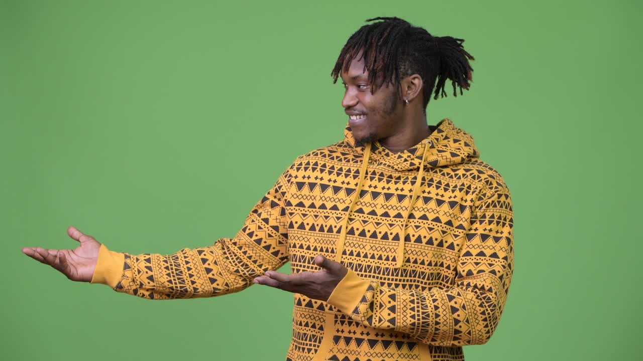 Young handsome African man showing something