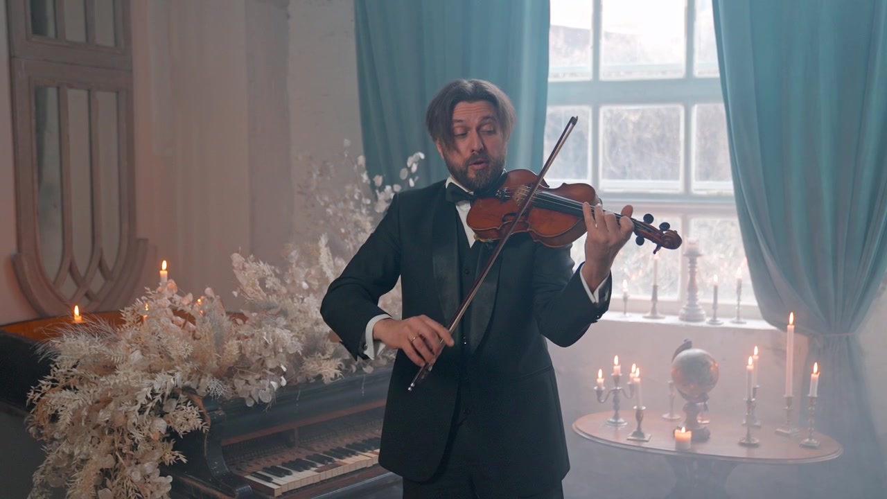 Uomo elegante in completo che suona il violino in una stanza drammatica