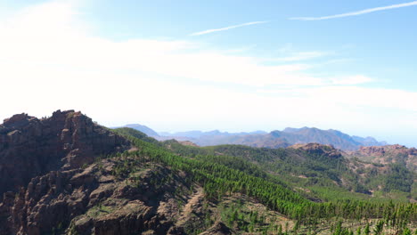panorama view landscape with wide view of hilltops and surrounding area full of trees and mountains, volcanic landscape during sunny days gran canary island 4k slow motion capture at 60fps.