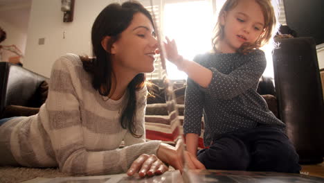 mother and daughter at home looking through photo album