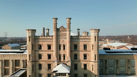 the facade of the joliet correctional center, abandoned historic prison covered in snow