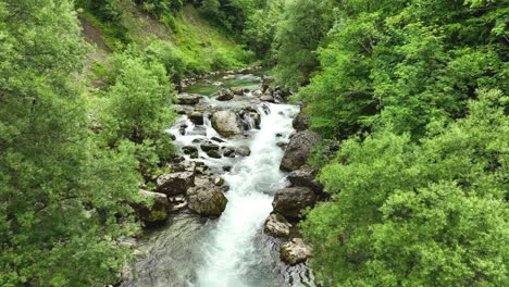 Natürlicher-Wasserstrahl,-Fluss-Zwischen-Felsen,-Steinwald-Im-Logartal-Slowenien,-Luftdrohnenansicht