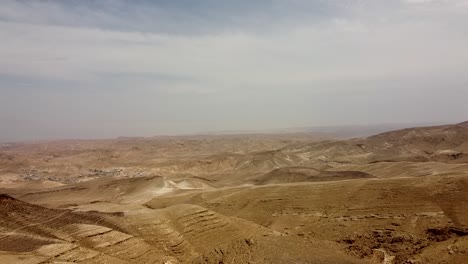 Aerial,-upward,-slow-drone-shot-of-a-beautiful-and-colorful-view-of-an-empty-desert-below-cloudy-sky