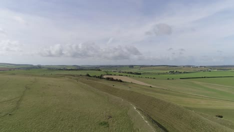 Seguimiento-Aéreo-Hacia-Arriba-Desde-El-Castillo-De-La-Doncella-Para-Revelar-Las-Murallas-Del-Norte-Y-La-Vasta-Campiña-De-Dorset-Que-Rodea-La-Gigantesca-Estructura.