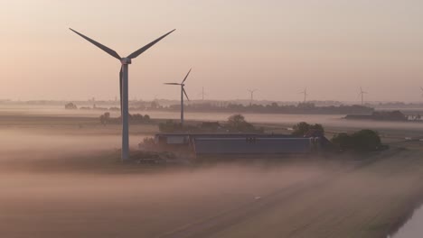 Windturbinen-Drehen-Sich-Morgens-Mit-Nebel,-Antenne