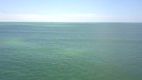 flying a few meters over the pacific ocean with a drone in a sunny day with the horizon in the background