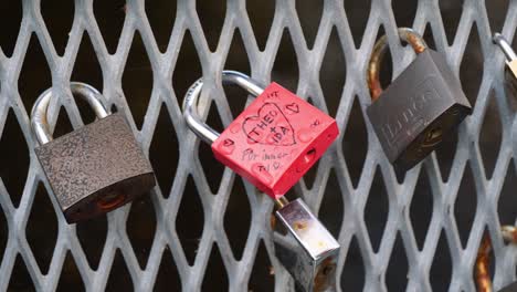 Close-up-or-detail-shot-of-three-locks-hanging-on-a-fence