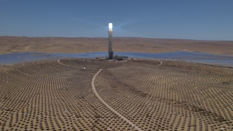 deslizándose sobre un enorme sistema de torre de espejos de energía solar térmica en un desierto desolado