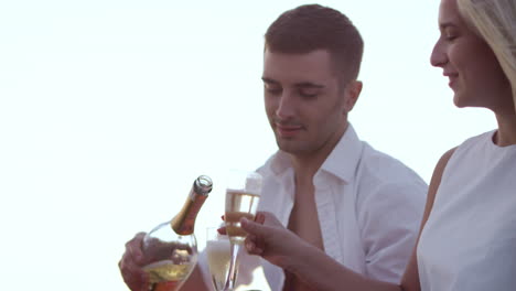 cute young couple drinking wine at sunset