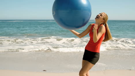 Mujer-Feliz-Jugando-Con-Su-Pelota-De-Fitness-En-La-Playa-