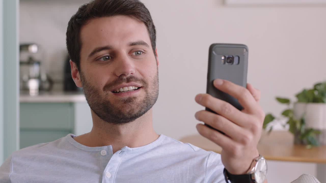 hombre caucásico atractivo teniendo video chat usando teléfono inteligente en casa mostrando su peinado hablando compartiendo estilo de vida disfrutando de la comunicación en línea