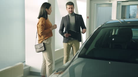 car dealership salesman discussing a car with a customer