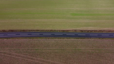 Black-tarmac-mac-road-running-between-two-fields