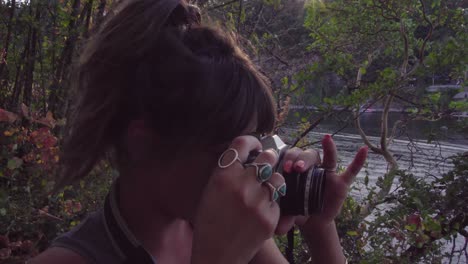 cute hipster girl talking and then holding up a film camera with a lens flare