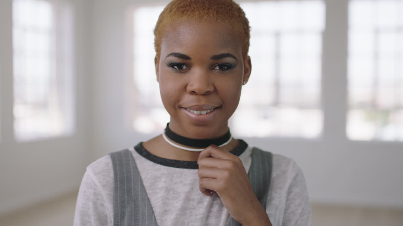 ritratto di una donna afroamericana alla moda che guarda pensosa alla telecamera una donna nera di successo in un nuovo appartamento