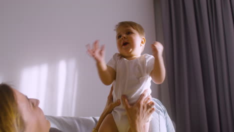 woman lying on the sofa at home while playing with her baby 2