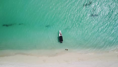 Fotografía-Cenital-De-Una-Lancha-Anclada-Frente-A-Una-Costa-Caribeña