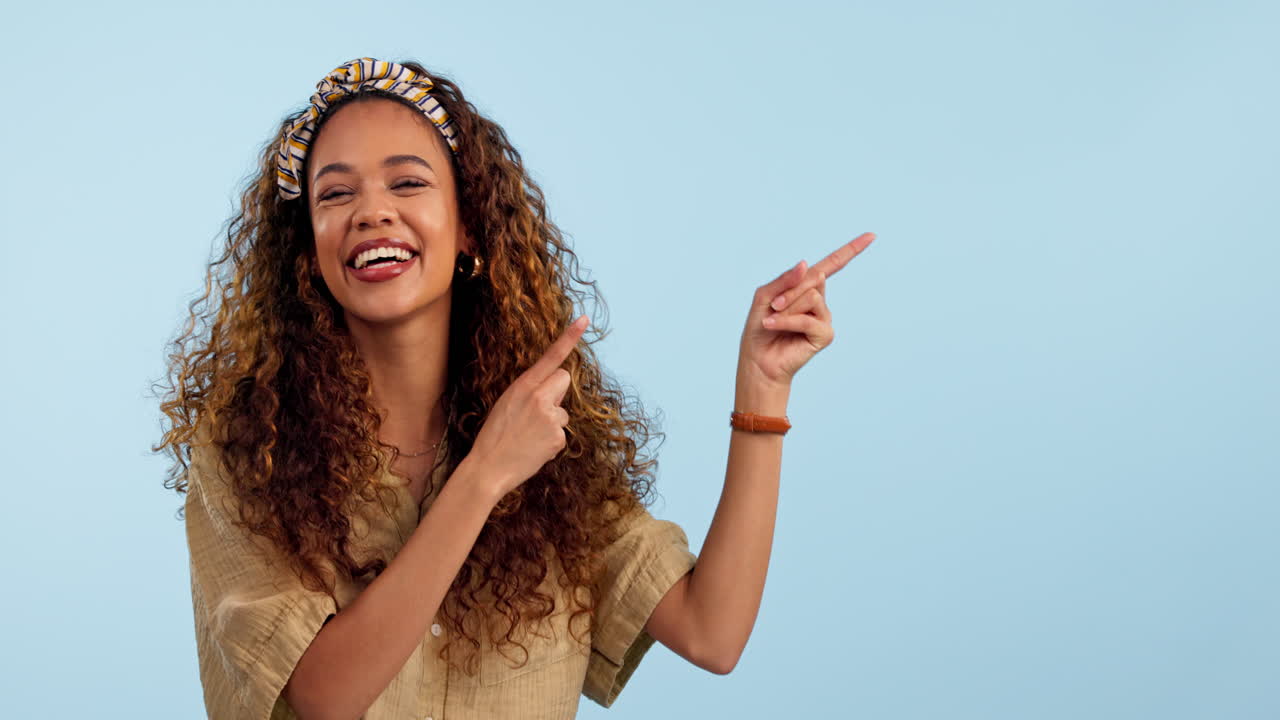 Smile, pointing and face of woman in a studio