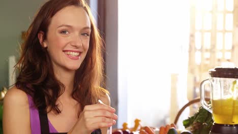 Female-staff-sipping-glass-of-juice-with-straw