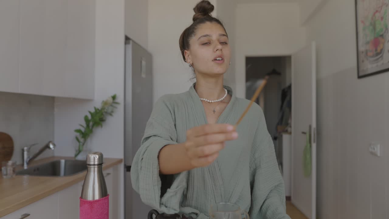 Woman in kitchen with tea set and incense