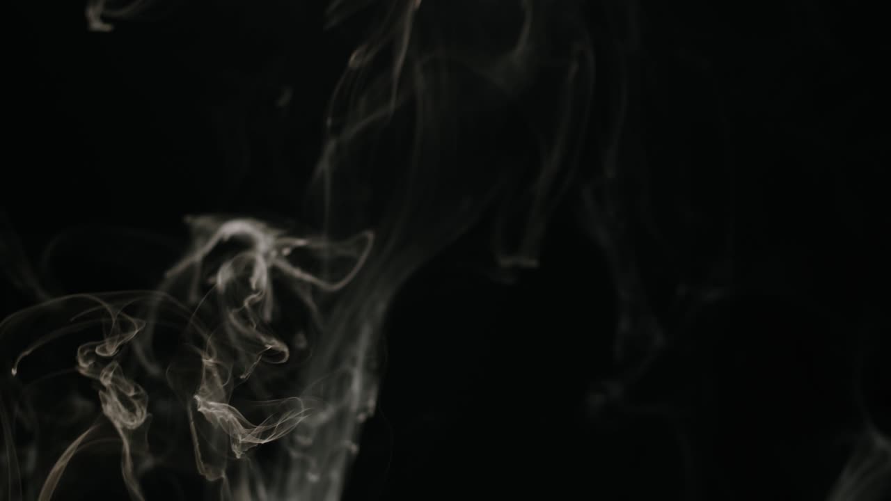 Fumo bianco vorticoso che sale su sfondo nero
