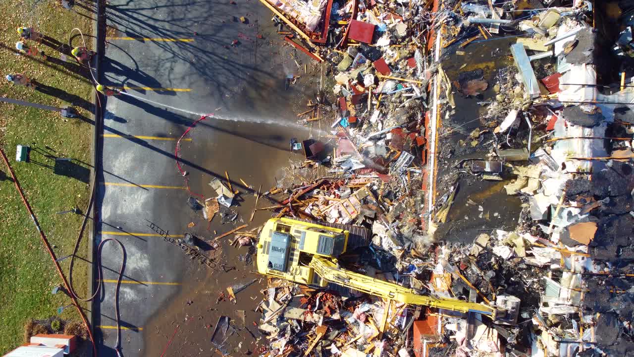 edificio aplanado por la excavadora después del incendio y lavado por los bomberos
