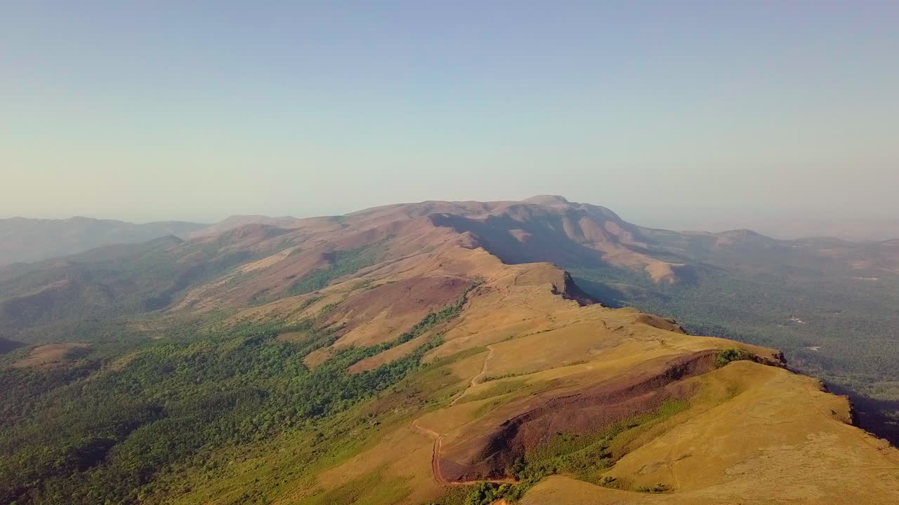 Sunlit view of Chikmagalur hills with rolling green valleys and rugged mountain peaks