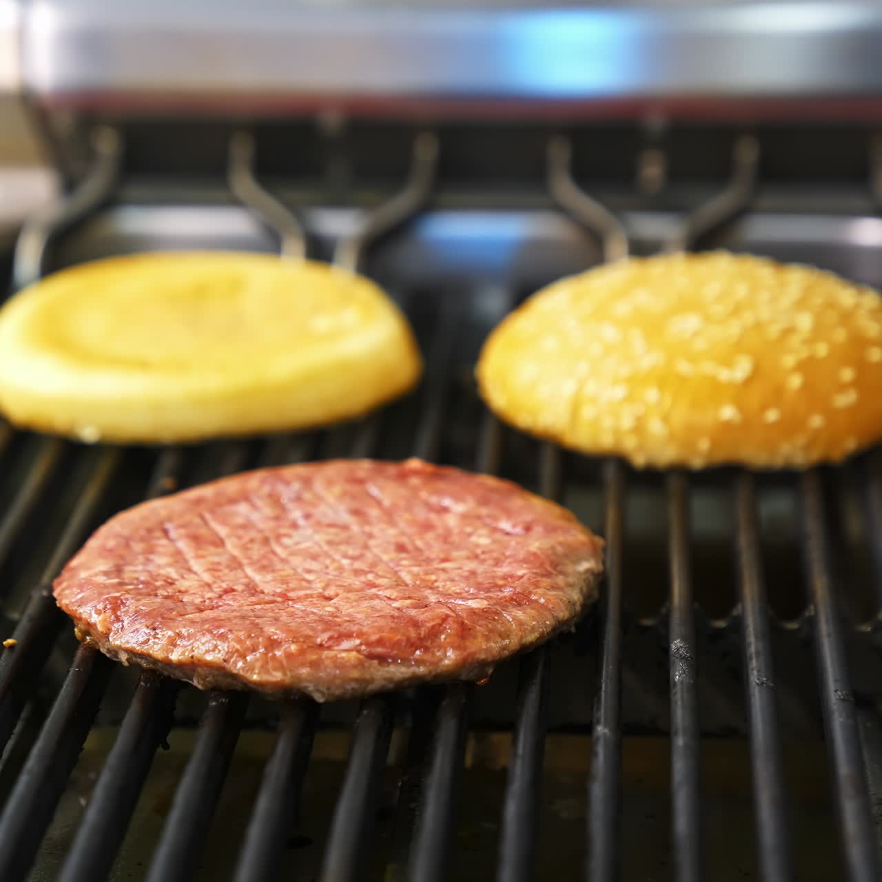 Frying meat and burgers on stove. Preparing burger and beef for hamburger. Cooking hamburger on hot grill pan in fast food restaurant. Close-up