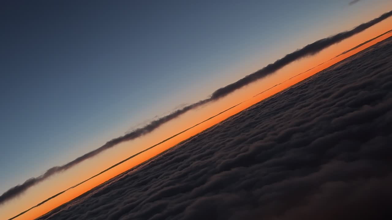 Vista do piloto capturada do cockpit de um horizonte dourado, momentos antes do nascer do sol, enquanto faz uma curva à direita sobre uma camada de nuvens