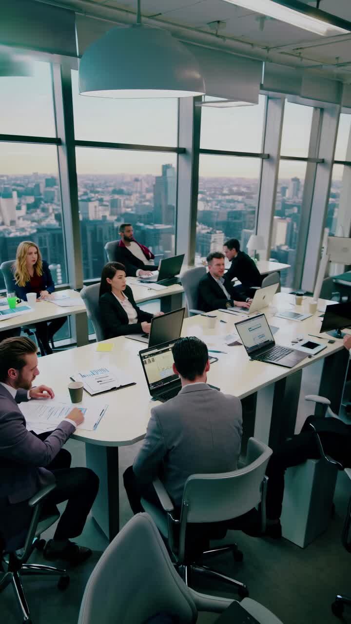 High-angle video of a modern office meeting, showcasing professionals engaged in discussion