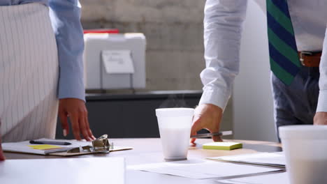 Mid-section-of-male-and-female-business-people-at-a-meeting