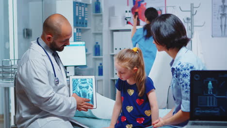 male pediatrician checking bone x-ray on tablet