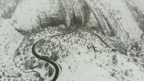 aerial push in shot of a country road during a fresh snowfall in the mountains of california.