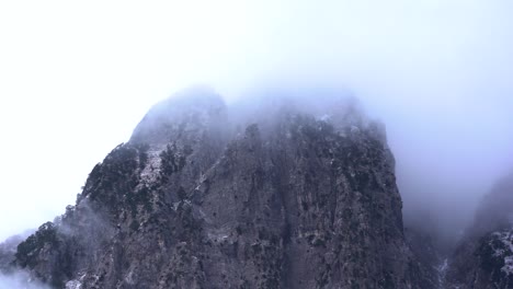 Misty-fog-on-top-of-Albanian-Alps-covering-high-mountain-peak-at-Winter,-time-lapse