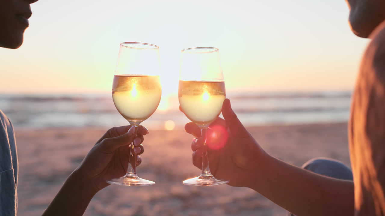 puesta de sol, playa y manos de pareja con vino
