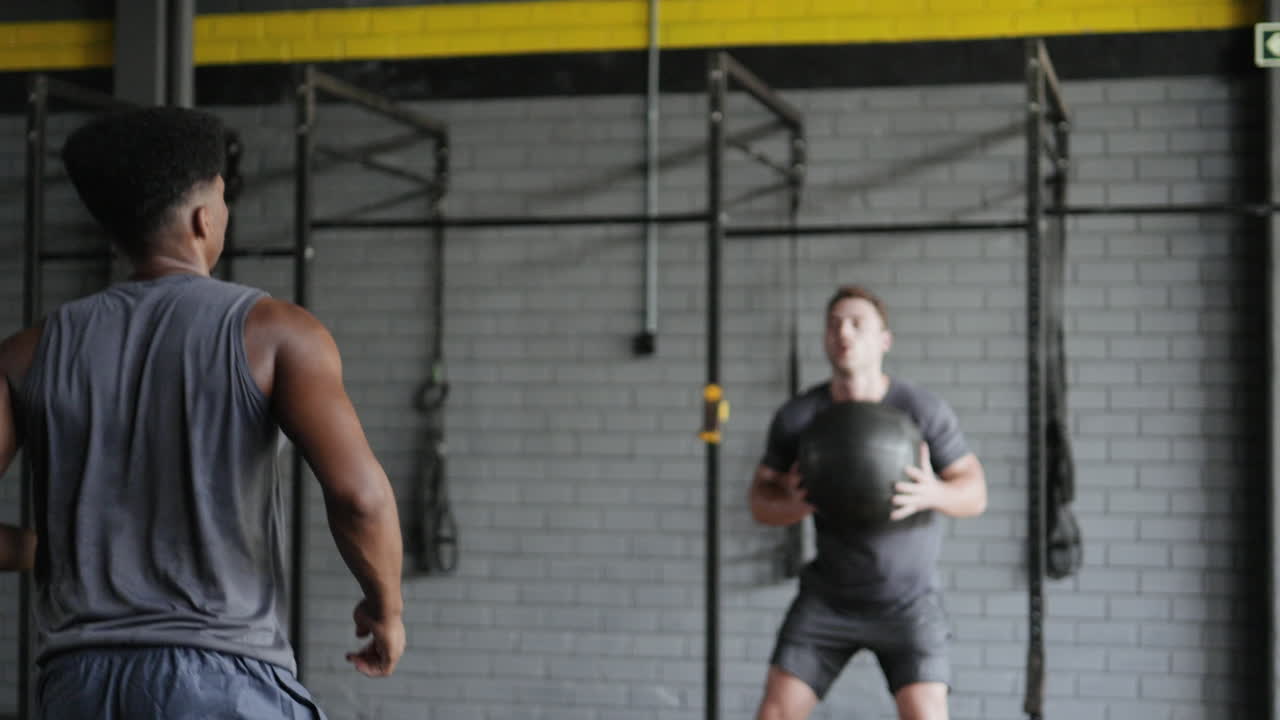 체육관 에서 의약품 공 을 가지고 운동 하는 남자 들