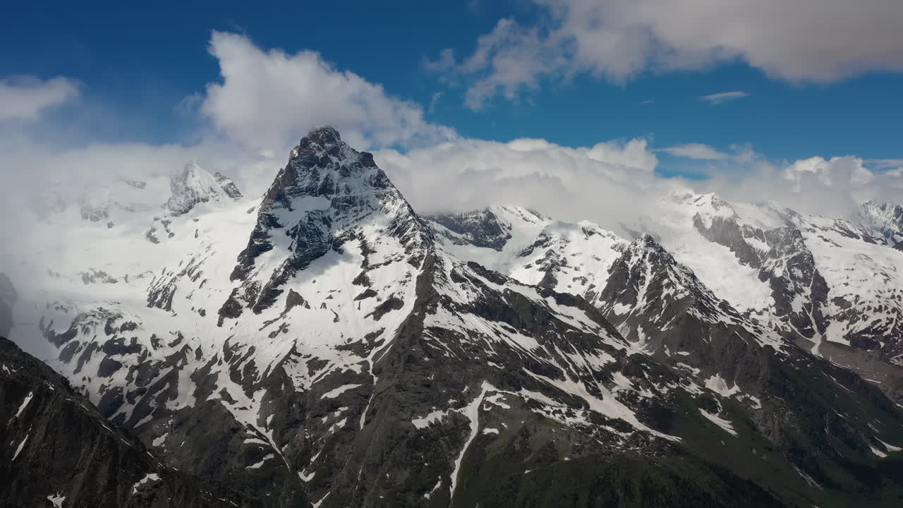 vuelo aéreo a través de nubes montañosas sobre hermosos picos nevados de montañas y glaciares.