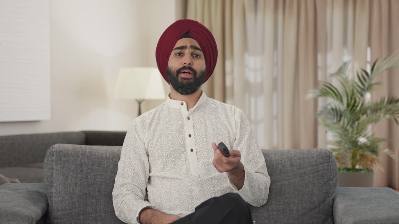 hombre indio sikh cansado y somnoliento viendo la televisión