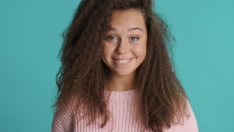 Caucasian-curly-haired-woman-nodding-in-front-of-the-camera.