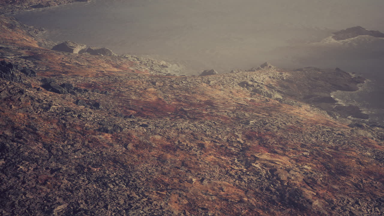 un río claro con rocas conduce hacia las montañas iluminadas por la puesta de sol