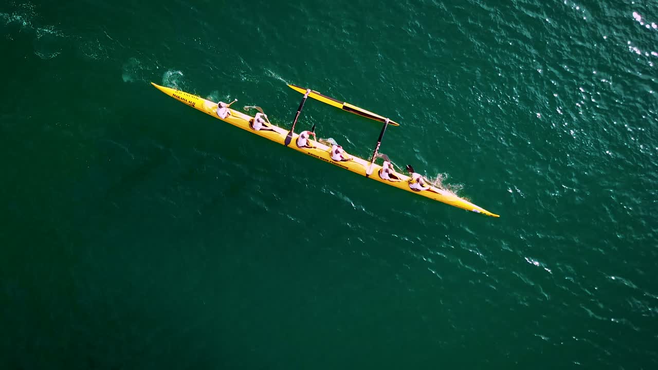 Beautiful aerial over an outrigger canoe paddled on blue water 1