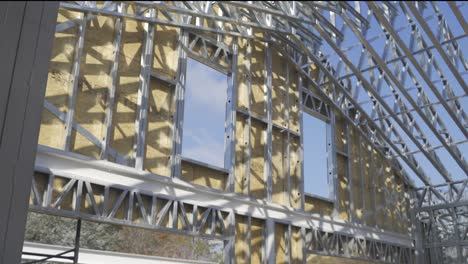 toma panorámica de una casa de estructura de acero de nueva construcción en el sitio de construcción a la luz del sol