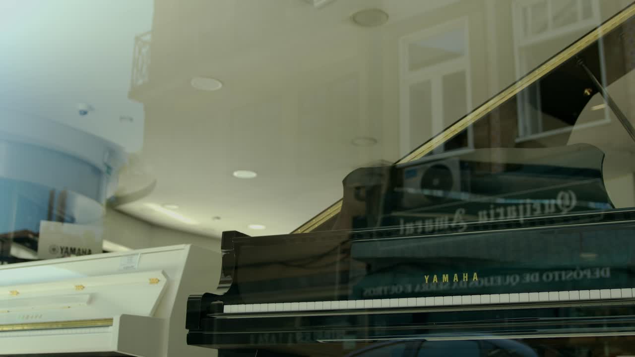 A piano in a window and the reflexion of a car passing by.