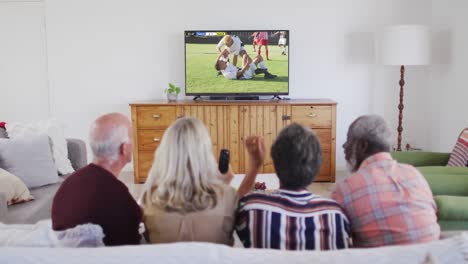 Video-Von-Verschiedenen-älteren-Freunden,-Die-Auf-Dem-Sofa-Sitzen-Und-Zu-Hause-Fußball-Schauen