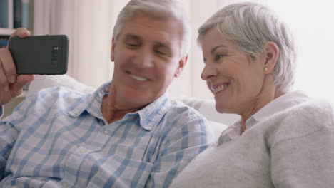 happy old couple having video chat using smartphone waving at grandchildren enjoying chatting to family on mobile phone sharing lifestyle relaxing at home on retirement 4k